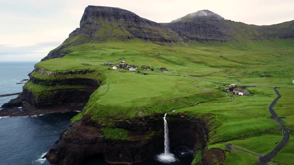 Aerial view of Mulafossur waterfall near a small village, Faroe island.
