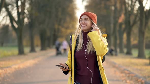 Happy Blonde Woman Walking in The Autumn Park