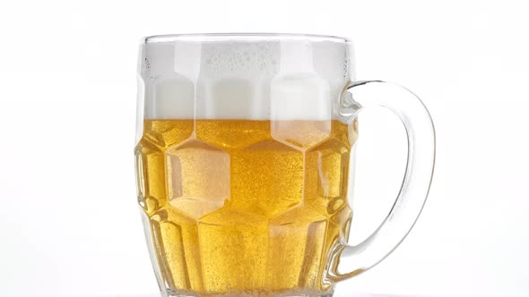 glass of fresh beer isolated on white background, rotation