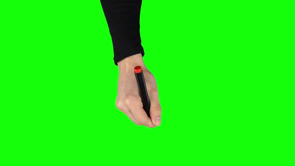 Male Hand in a Black Sweater with Red Marker Is Writing on Green Screen Background. Close Up