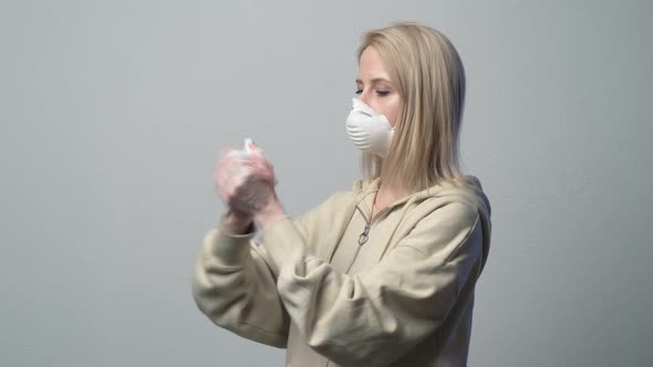 Blonde woman in protective mask with disinfection gel