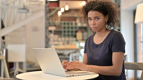 Young African Woman with Laptop Showing Thumbs Down