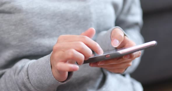 Body part of woman using cellphone