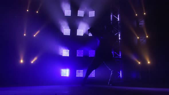 Silhouette of a Talented Young Hip Hop Dancer. Hip Hop Street Dance on a Stage in Dark Studio with