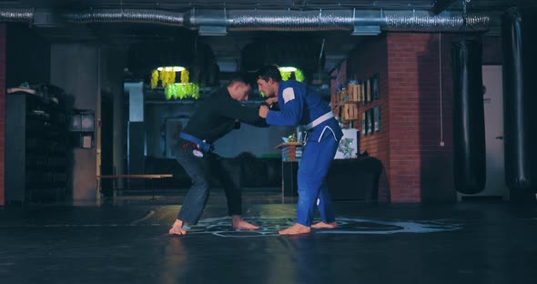 Fighters in a Kimono Train Capture with a Coup Techniques of Jujitsu