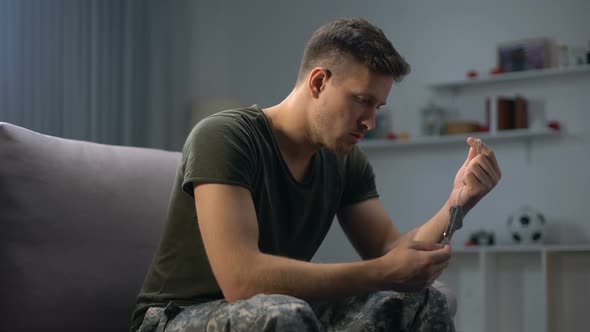 Depressed Male Soldier Holding ID Military Tag of Best Friend