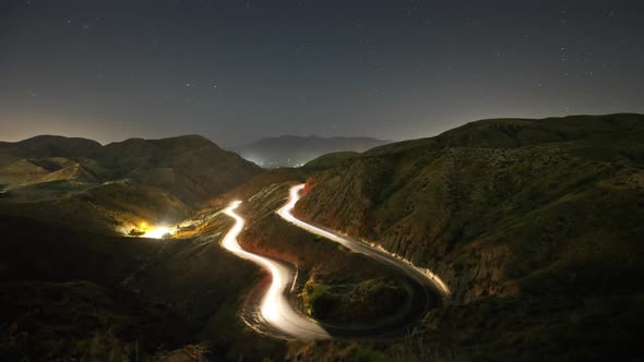 Night time lapse of a road winding through the mountains