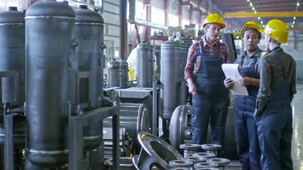 Female Supervisor Talking to Factory Workers