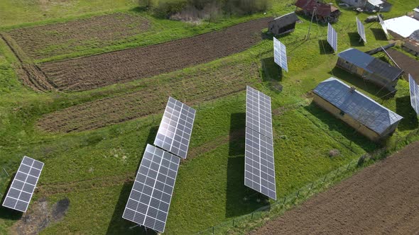 Aerial View of Blue Photovoltaic Solar Panels Mounted on Backyard Ground for Producing Clean