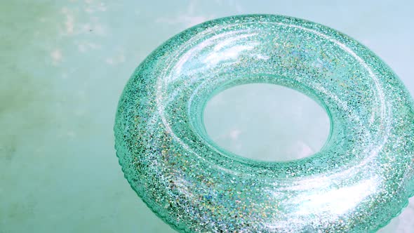 Shiny Inflatable Circle FloatIng on the Water Surface of an Empty Swimming Pool