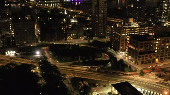 An aerial view at night over the Brooklyn Bridge entrance on the Brooklyn side. As traffices around