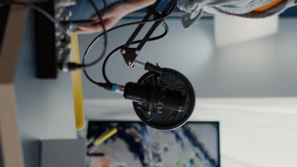 Vertical Video Young Woman Sitting at Podcast Desk with Microphone and Laptop