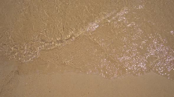 Slowmotion Shot. A Lettering COVID on the Sand Is Being Washed Away By the Sea. Concept of the End
