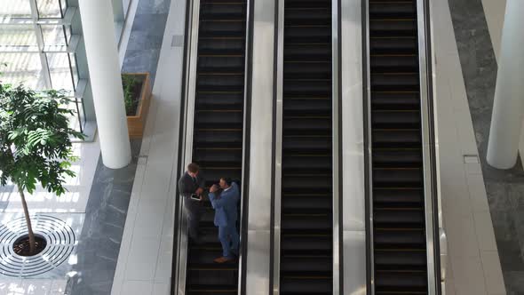 Businessmen on an escalator in a modern building