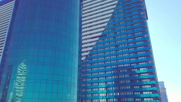 shot of reflections of sun, clouds and sky on glass windows of city skyscraper.