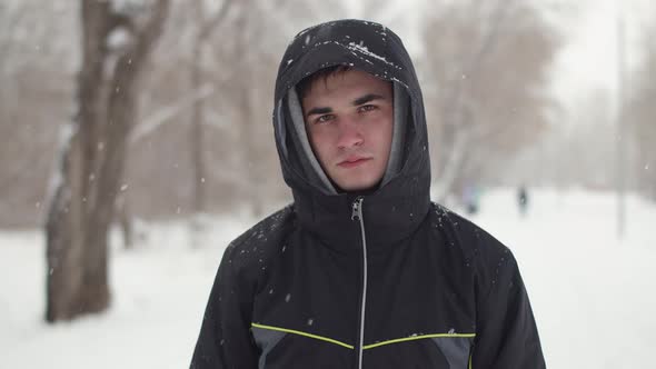 Man Stands in Park Winter and Looks at the Camera