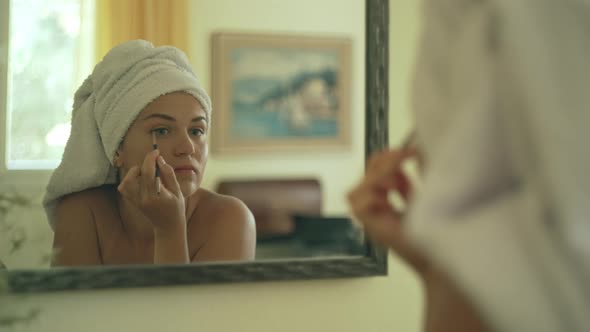 Caucasian Woman Doing Eye Makeup in Front of the Mirror