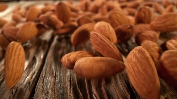 Super Slow Motion Detail Shot of Almonds Rolling Towards on Wooden Background at 1000Fps