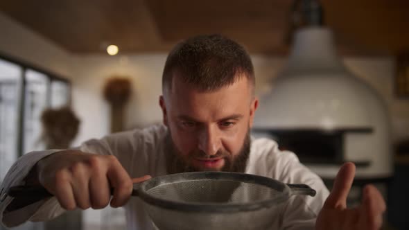 Baker Man Sifting Flour Using Sieve in Culinary Restaurant