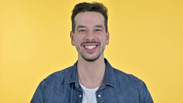 Portrait of Attractive Young Man Doing Video Chat, Yellow Background