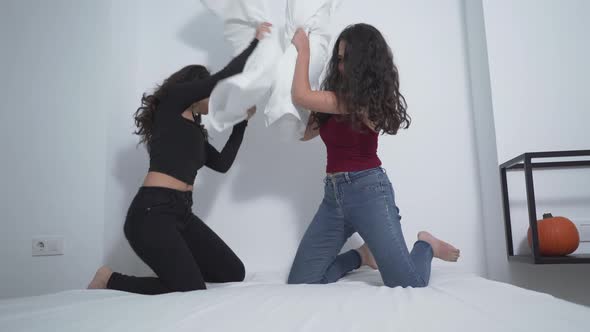 Two Attractive Colombian Women In Sexy Outfit Having Great Fun Pillow Fighting On Bed Of An