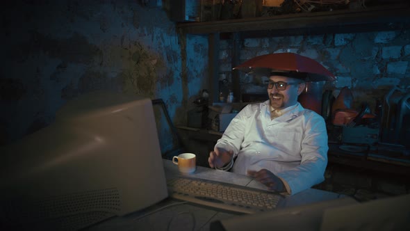 Computer nerd with an umbrella on his head in an old garage. Video conference in group virtual chat