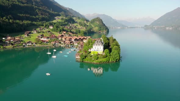 Droneview on famous castle Seeburg in Iseltwald, Switzerland. Early morning light over the lake with