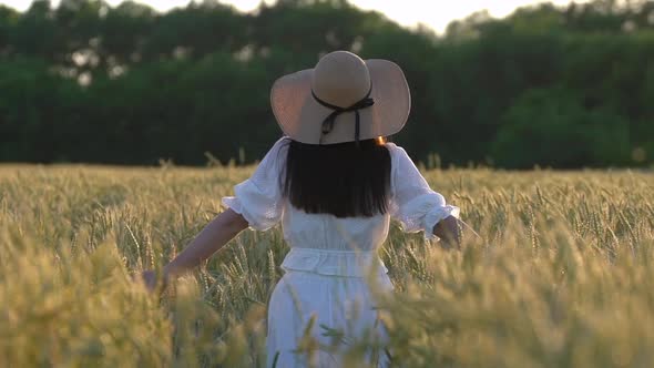 Young Girl Walking in Slow Motion Through a Wheat Field