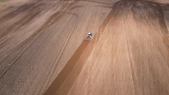 Tractor Plows Ground on Cultivated Farm Field