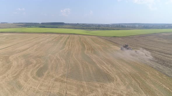 Aerial view of a tractor plowing in the fields