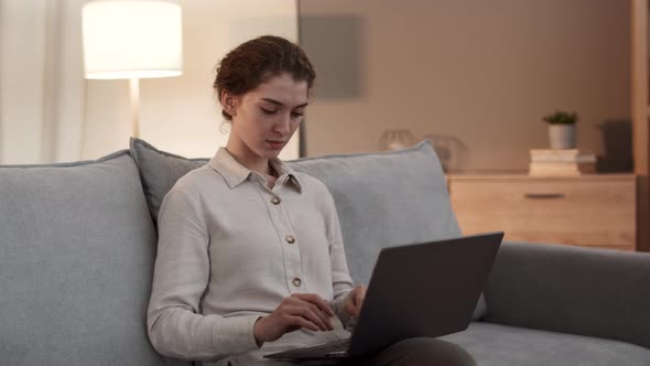 Female Adult Using Laptop on Couch