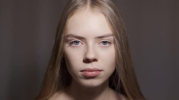 Young Woman Open Eyes on White Background. Close Up of Smiling Girl Looking at Camera in Studio.