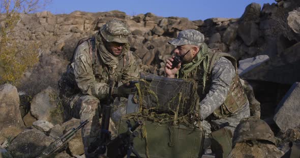 Armed Soldiers Looking at a Computer alt