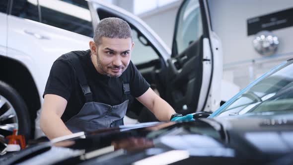 A Man Rubs the Surface of the Car After Polishing