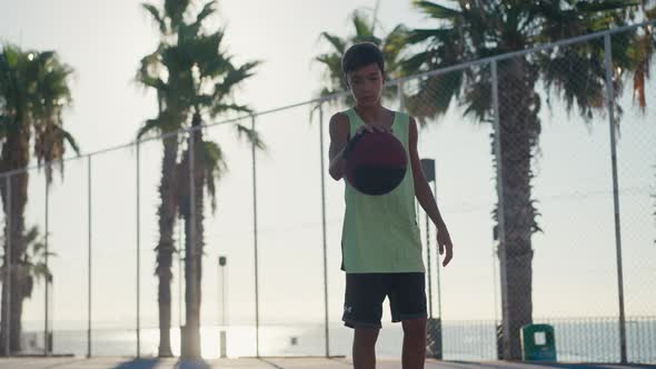 Young Caucasian Boy Basketball Player Dribbling and Practicing Ball Handling Skill on Court