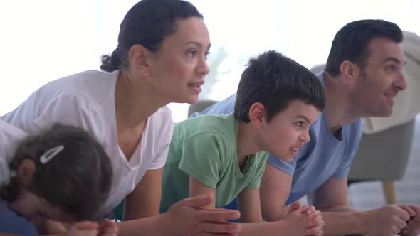 Healthy Family Practicing Yoga Exercise Indoors