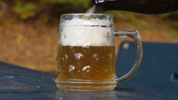 Delicious bottle of beer flows into a classic German beer glass