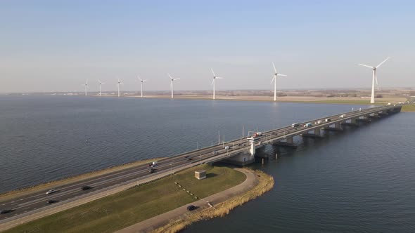 Drone flying towards highway on Bascule bridge, windmills in background. Ketelbrug