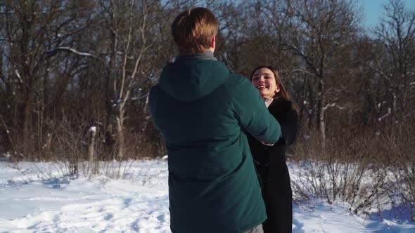 Happy Couple Whirling in Winter Forest