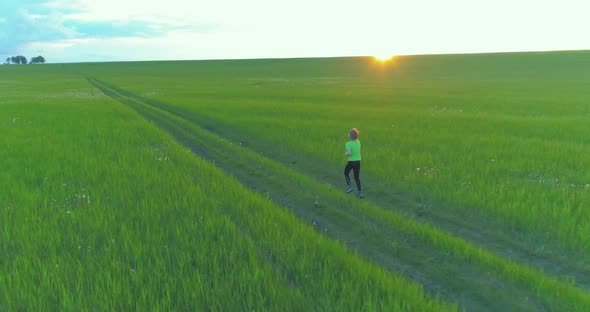 Sporty Child Runs Through a Green Wheat Field