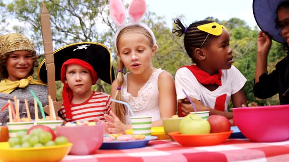 Group of kids in various costumes having breakfast