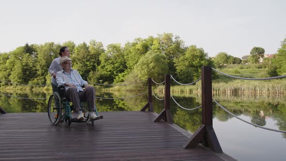 Nurse Walking with Old Man in Wheelchair