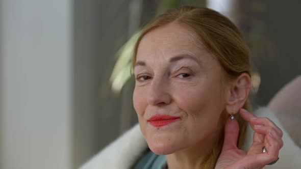 Headshot Portrait of Confident Smiling Rich Caucasian Middle Aged Woman Touching Expensive Earring