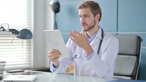 Doctor Talking on Video Call on Tablet in Clinic