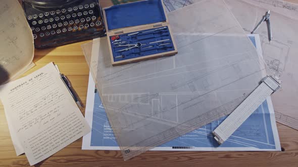 Vintage architecture desk with typewriter, blueprints and rulers