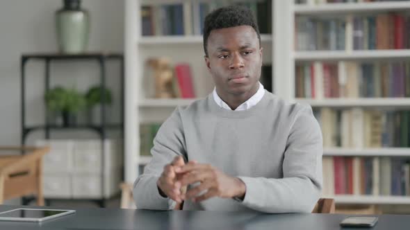 Pensive African Man Thinking While Sitting in Library