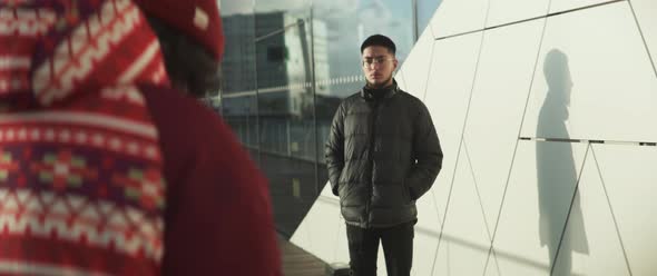 Young male model with glasses is being given directions by photographer