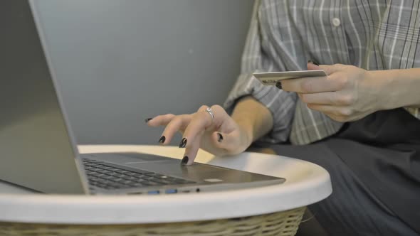 American Businesswoman Shopping Online Using Credit Card and Laptop Computer in Office