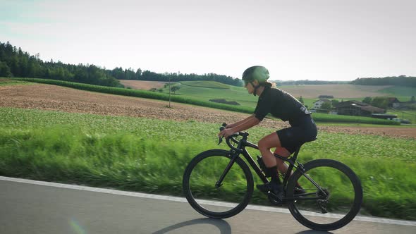 Female cyclist riding bicycle at sunset