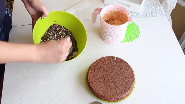 A Woman Mixes Peanuts And Chocolate In A Container.